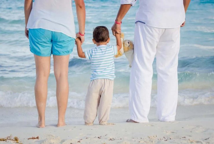 Bambino al mare con i genitori 