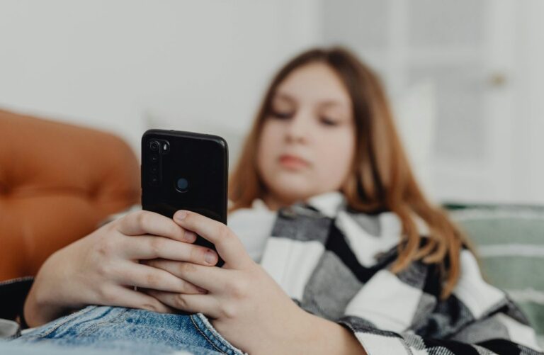 ragazza su divano che guarda cellulare immagine per ghosting