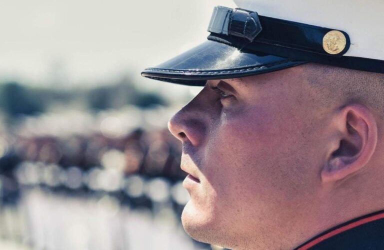 Primo piano di profilo di un militare dei Marines in alta uniforme con cappello bianco d'ordinanza, serie Boots Netflix.