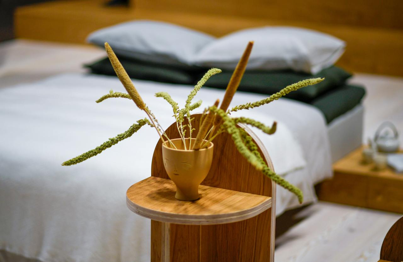 Dettaglio camera da letto minimalista e ordinata con piante ed elementi in legno per l'energia positiva in casa