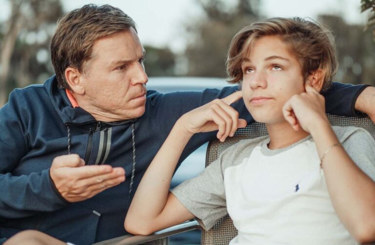 padre che parla al figlio che si copre le orecchie concetto cosa dicono i genitori
