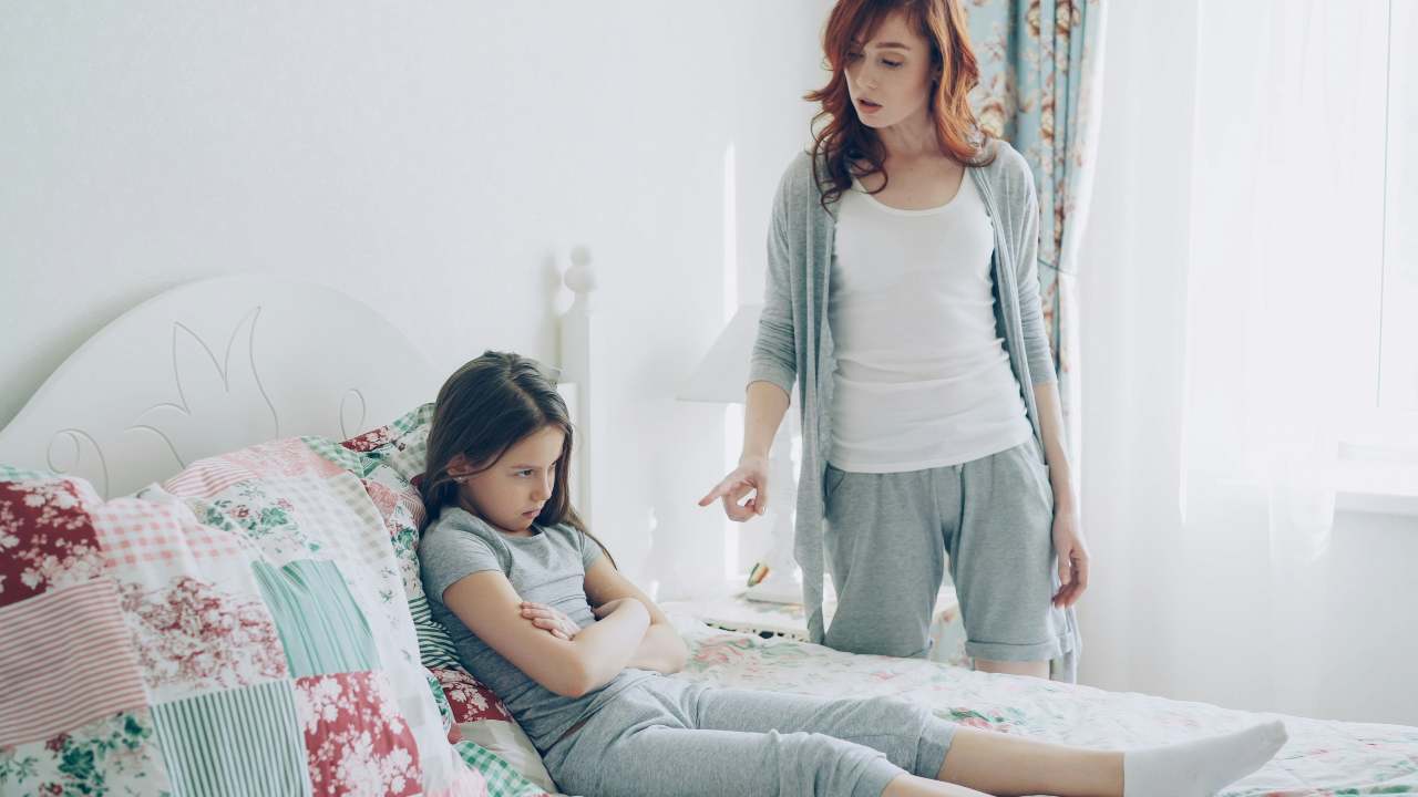mamma che rimprovera figlia sul letto
