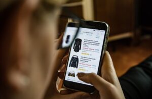 persona guarda giacche e vestiti a rate online su uno smartphone concetto compra ora paga dopo