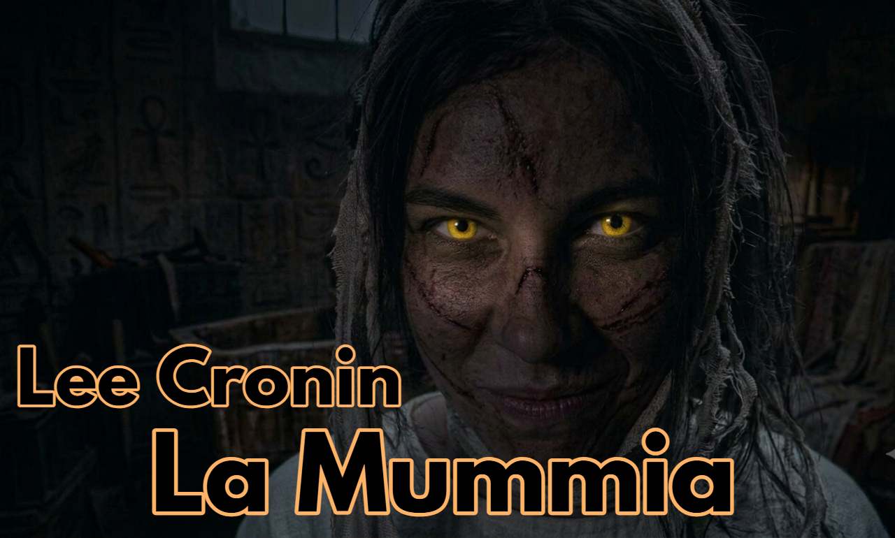 Primo piano ravvicinato del volto di una mummia interpretata da una donna con capelli scuri e disordinati, pelle segnata da graffi e intensi occhi gialli luminosi per il film lee cronin la mummia